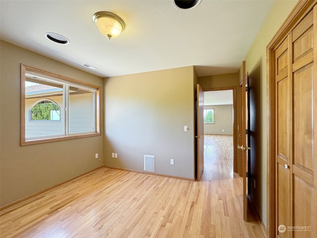 empty room featuring light wood-type flooring and plenty of natural light