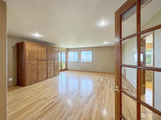 unfurnished bedroom featuring a textured ceiling and light hardwood / wood-style flooring