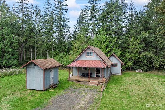 bungalow featuring a front lawn and a storage unit