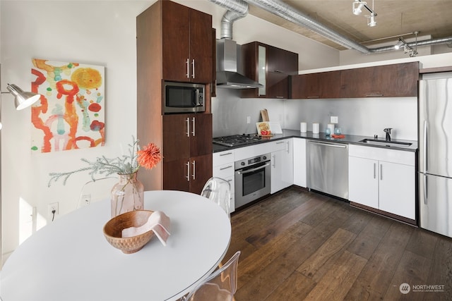 kitchen featuring white cabinets, wall chimney exhaust hood, dark hardwood / wood-style flooring, stainless steel appliances, and sink