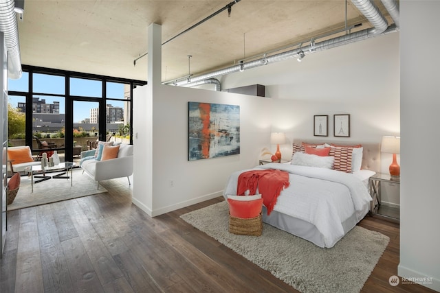 bedroom with a towering ceiling and dark wood-type flooring