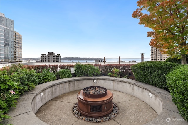 view of patio with a water view and an outdoor fire pit