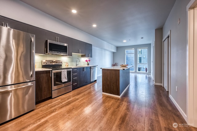 kitchen with hardwood / wood-style flooring, stainless steel appliances, and sink