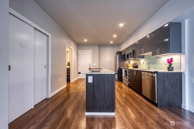 kitchen with a center island, stainless steel appliances, dark hardwood / wood-style floors, and sink