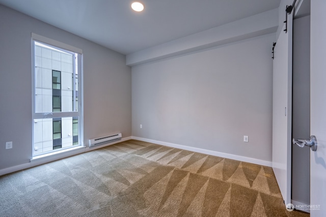 empty room with a barn door, carpet flooring, and baseboard heating