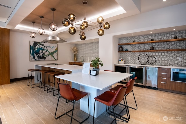 kitchen featuring hanging light fixtures, a breakfast bar, oven, and a center island