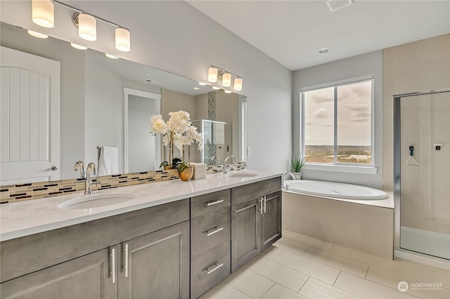 bathroom featuring double vanity, a stall shower, a sink, and a bath