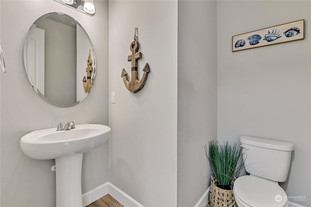 bathroom featuring baseboards and toilet