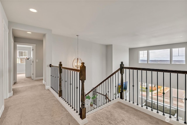 hallway with baseboards, an upstairs landing, carpet floors, a notable chandelier, and recessed lighting