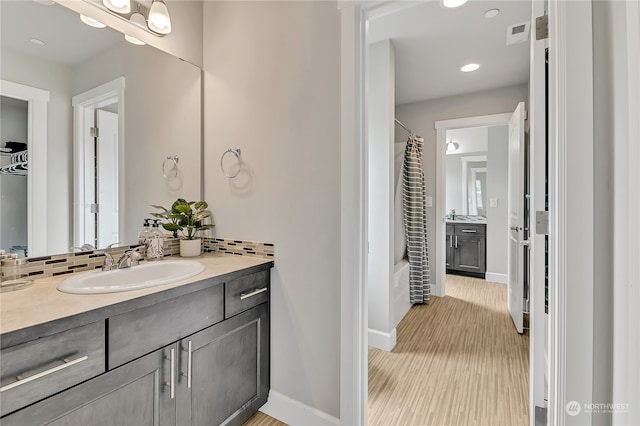 bathroom with shower / bath combo, vanity, and hardwood / wood-style flooring