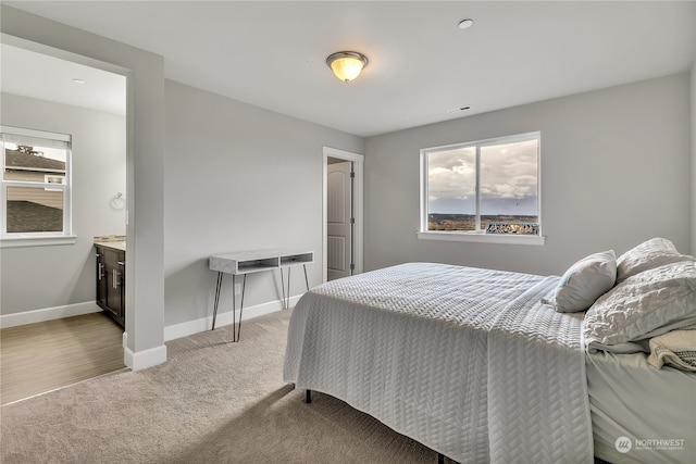 bedroom with light carpet and baseboards