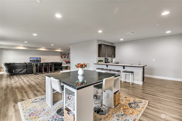 dining area with baseboards, light wood finished floors, visible vents, and recessed lighting