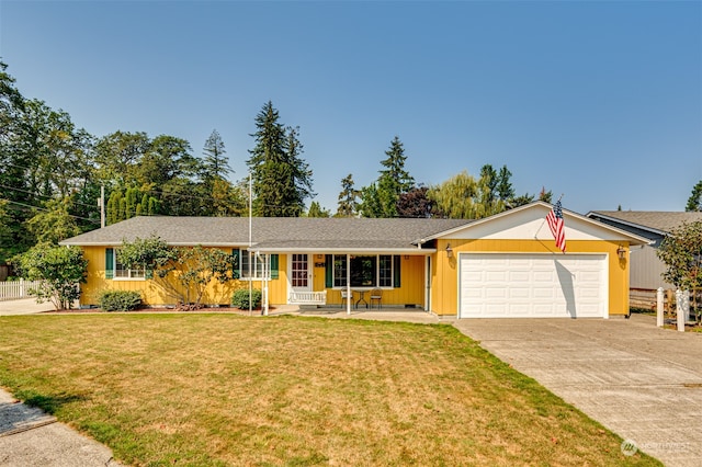 ranch-style home featuring a front yard, covered porch, and a garage