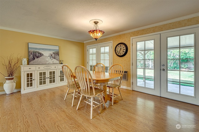 dining area with crown molding, french doors, a textured ceiling, and light wood-type flooring