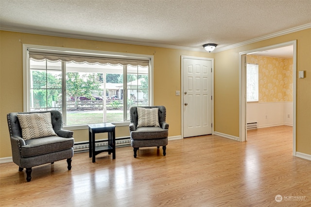 living area with a baseboard heating unit, light hardwood / wood-style floors, a textured ceiling, and crown molding