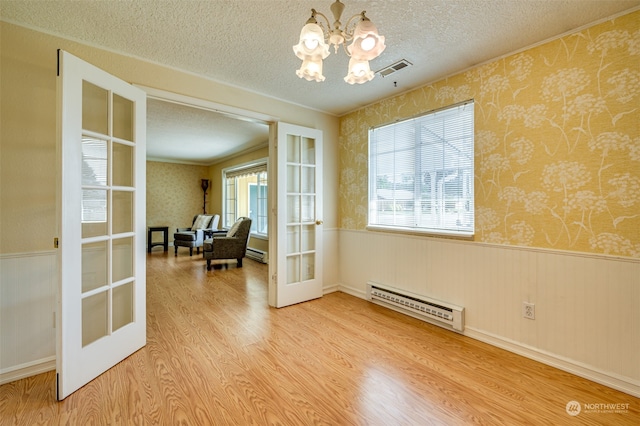 doorway to outside featuring baseboard heating, a chandelier, french doors, and hardwood / wood-style flooring