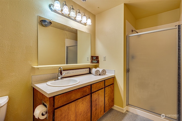 bathroom featuring an enclosed shower, vanity, and toilet