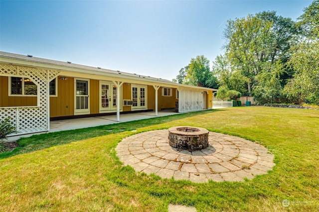 back of property featuring a yard, an outdoor fire pit, french doors, and a patio area