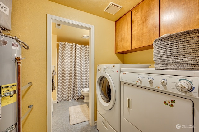 laundry room featuring washing machine and dryer, water heater, a textured ceiling, and light carpet