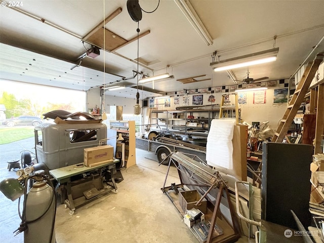 garage with a garage door opener, a workshop area, and ceiling fan