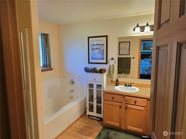 538 Canal Dr NE, Ocean Shores, WA 98569 - bathroom featuring a garden tub, wood finished floors, and vanity