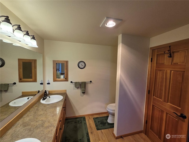538 Canal Dr NE, Ocean Shores, WA 98569 - bathroom featuring vanity, toilet, wood finished floors, and baseboards