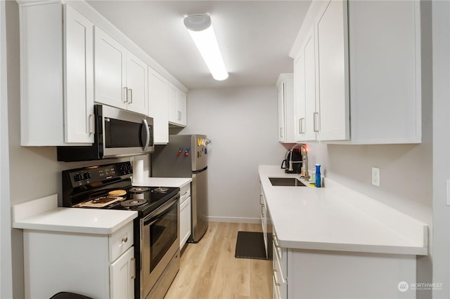 116 173rd St S, Spanaway, WA 98387 - kitchen with light wood finished floors, white cabinets, appliances with stainless steel finishes, and a sink