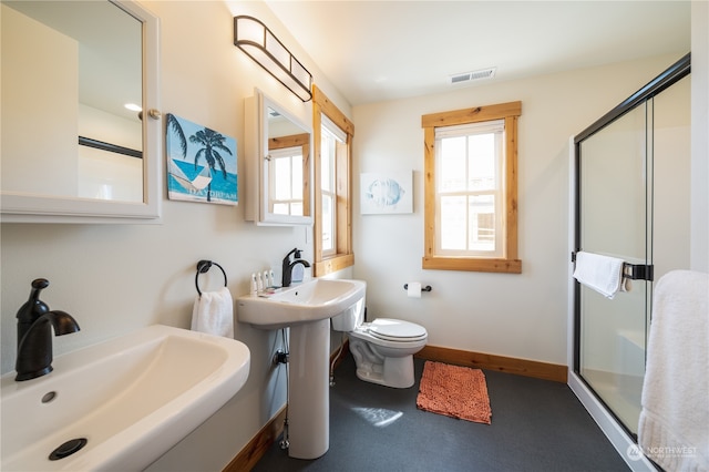 bathroom with toilet, a shower with shower door, and sink