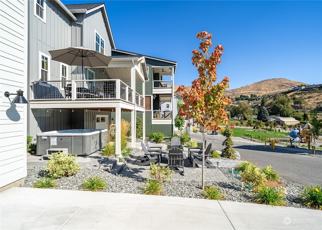 exterior space with a jacuzzi, a patio, and a mountain view