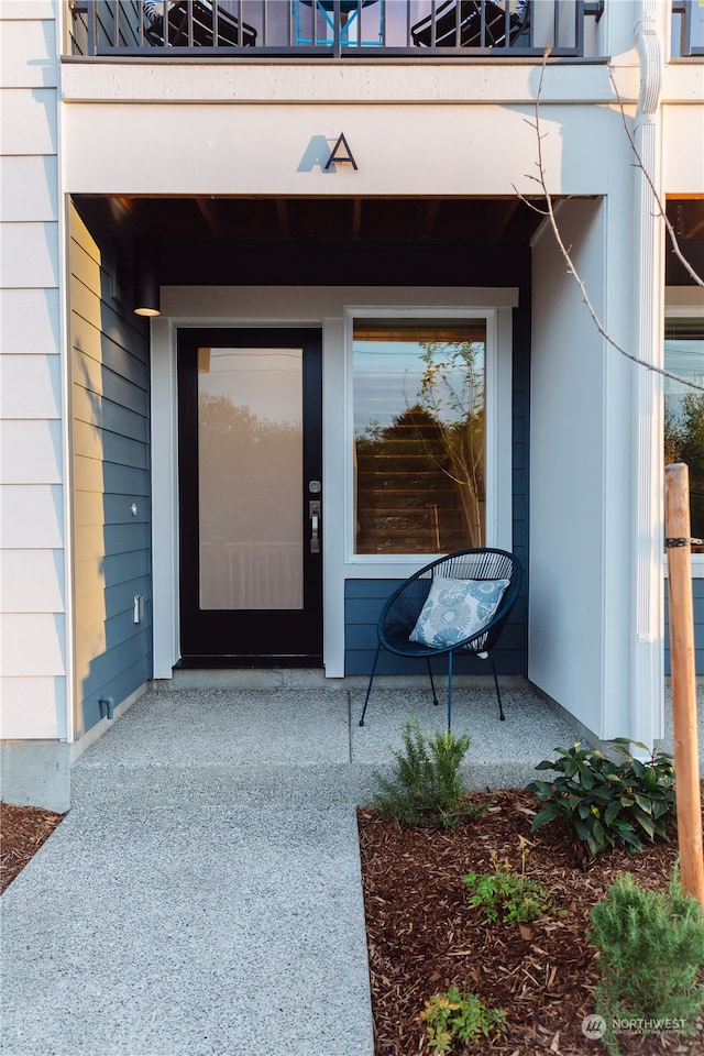 view of exterior entry featuring a balcony