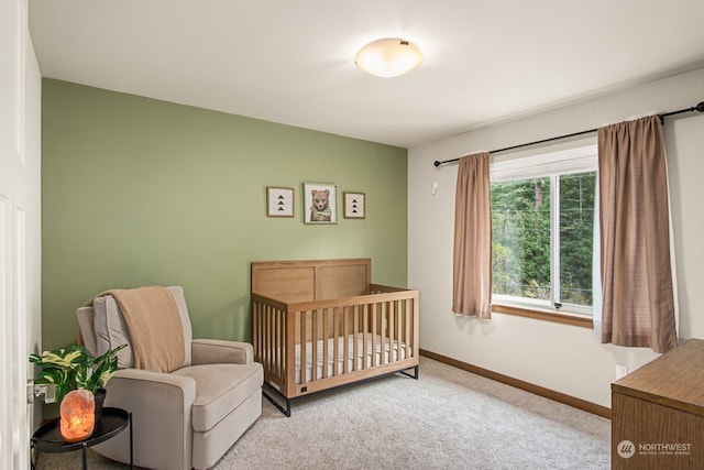 carpeted bedroom featuring a nursery area