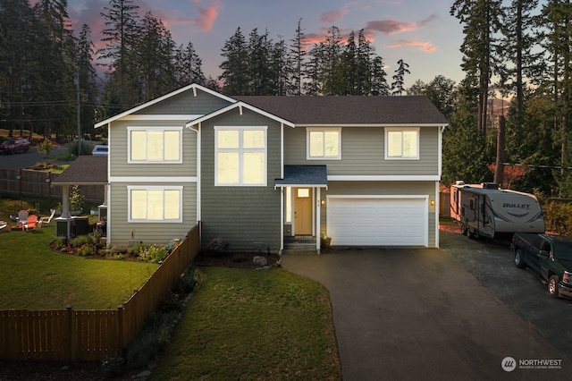 view of front of house with a garage and a lawn