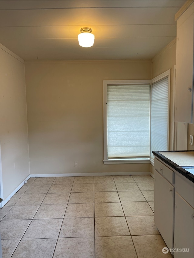 interior space featuring light tile patterned floors and white cabinets