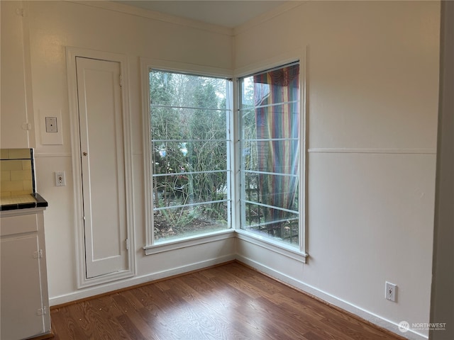 unfurnished dining area featuring light hardwood / wood-style flooring, plenty of natural light, and ornamental molding