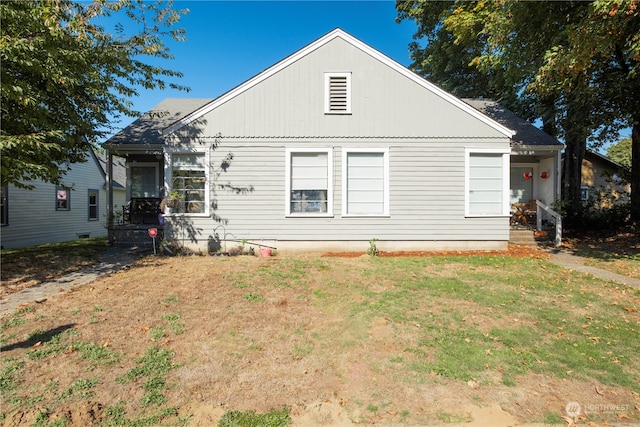 rear view of house featuring a yard