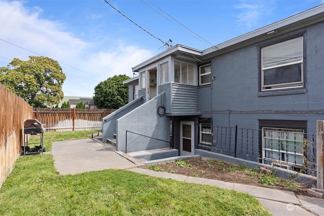 back of property featuring a lawn and a patio