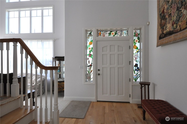 foyer entrance featuring a high ceiling and light hardwood / wood-style flooring