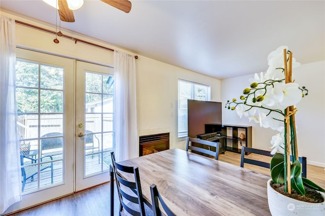 dining area featuring french doors, wood finished floors, a ceiling fan, and a healthy amount of sunlight