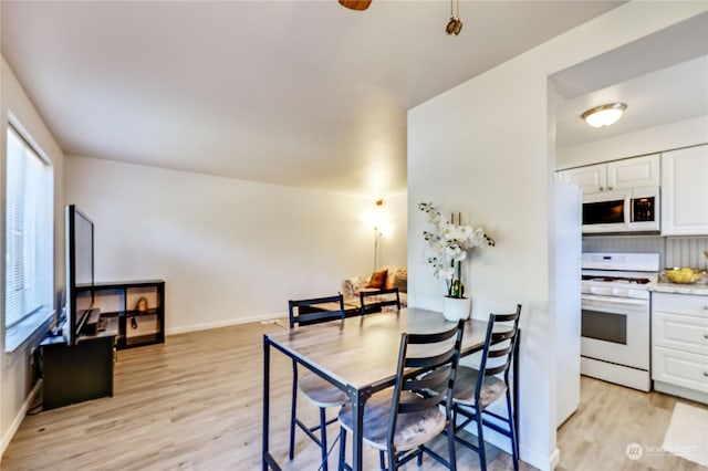 dining area featuring light wood finished floors and baseboards