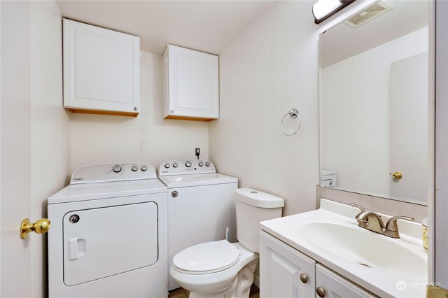 bathroom featuring vanity, toilet, and washing machine and clothes dryer