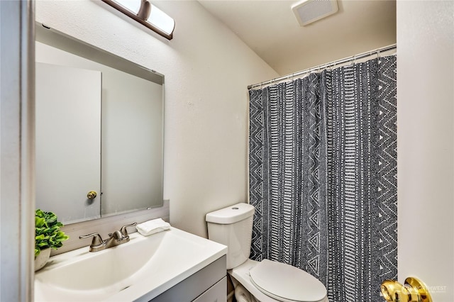 bathroom featuring a shower with shower curtain, visible vents, vanity, and toilet