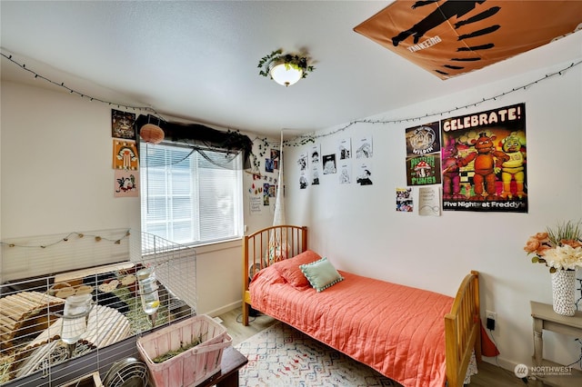 bedroom with baseboards and wood finished floors