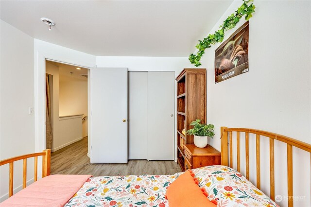 bedroom with light hardwood / wood-style flooring and a closet