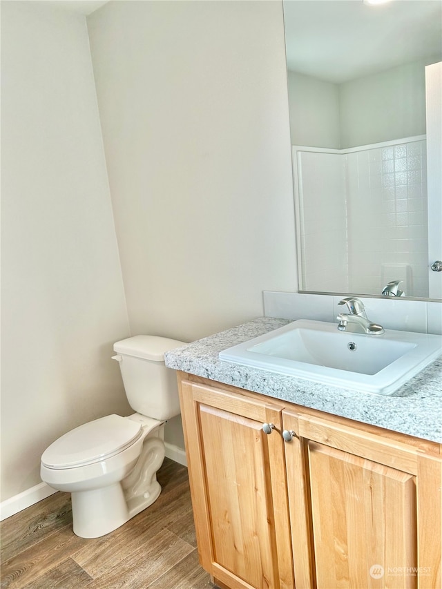 bathroom featuring wood-type flooring, vanity, and toilet