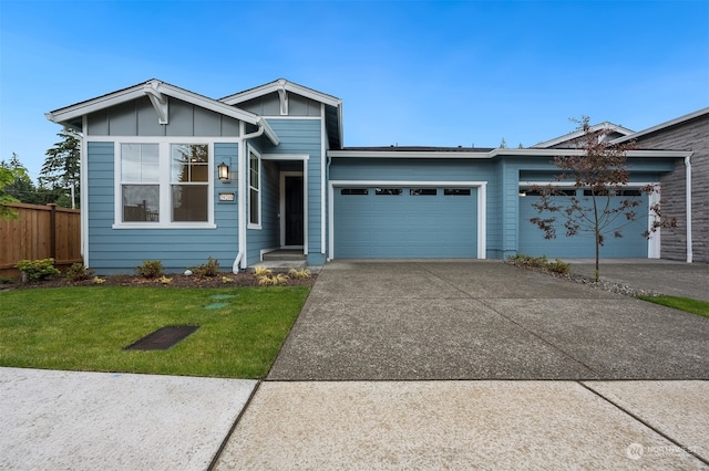 view of front of house with a garage, concrete driveway, fence, board and batten siding, and a front yard