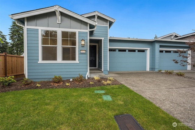 view of front of house with concrete driveway, an attached garage, board and batten siding, fence, and a front lawn