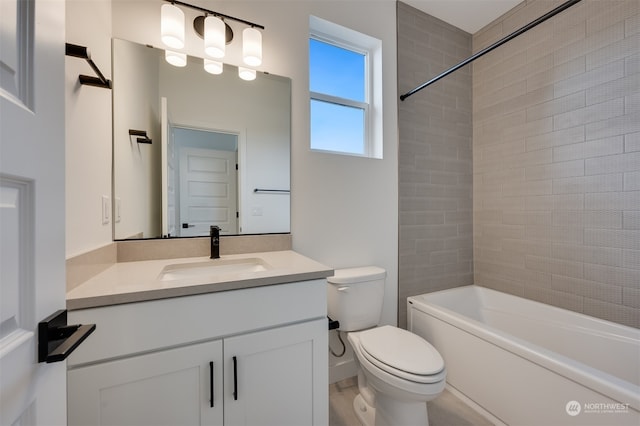 full bathroom with tiled shower / bath, vanity, and toilet