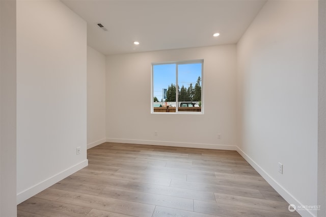 empty room with light wood finished floors, recessed lighting, visible vents, and baseboards