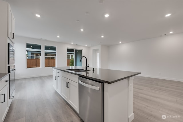 kitchen with dark countertops, appliances with stainless steel finishes, a sink, and recessed lighting