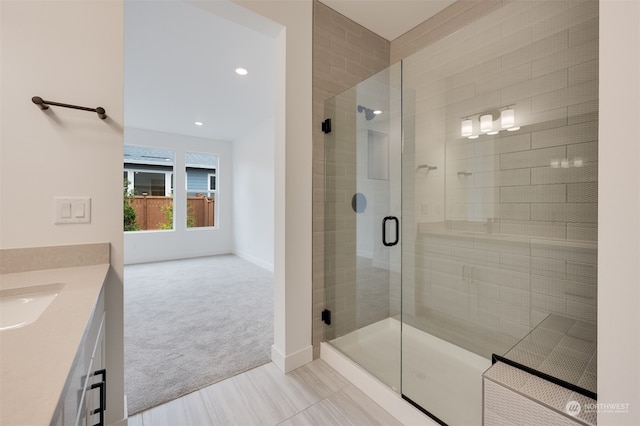 bathroom with a stall shower, vanity, and baseboards